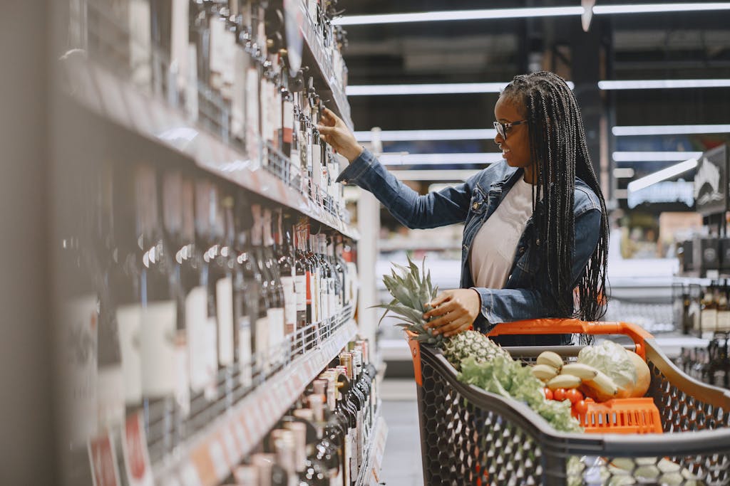 A woman shopping in the wine aisle of a grocery store, representing the everyday places where strangers unexpectedly open up and seek spiritual clarity.