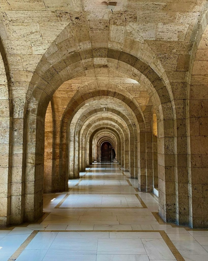 arched stone corridor representing institutional spiritual authority and power