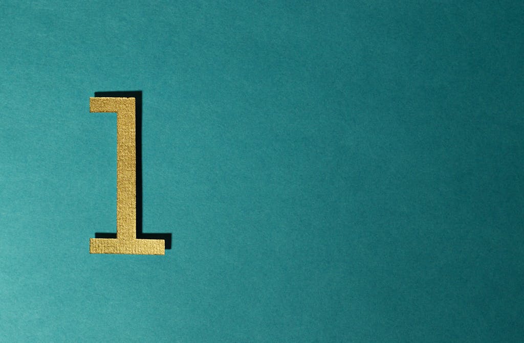A gold number one on a teal background with ample copy space.