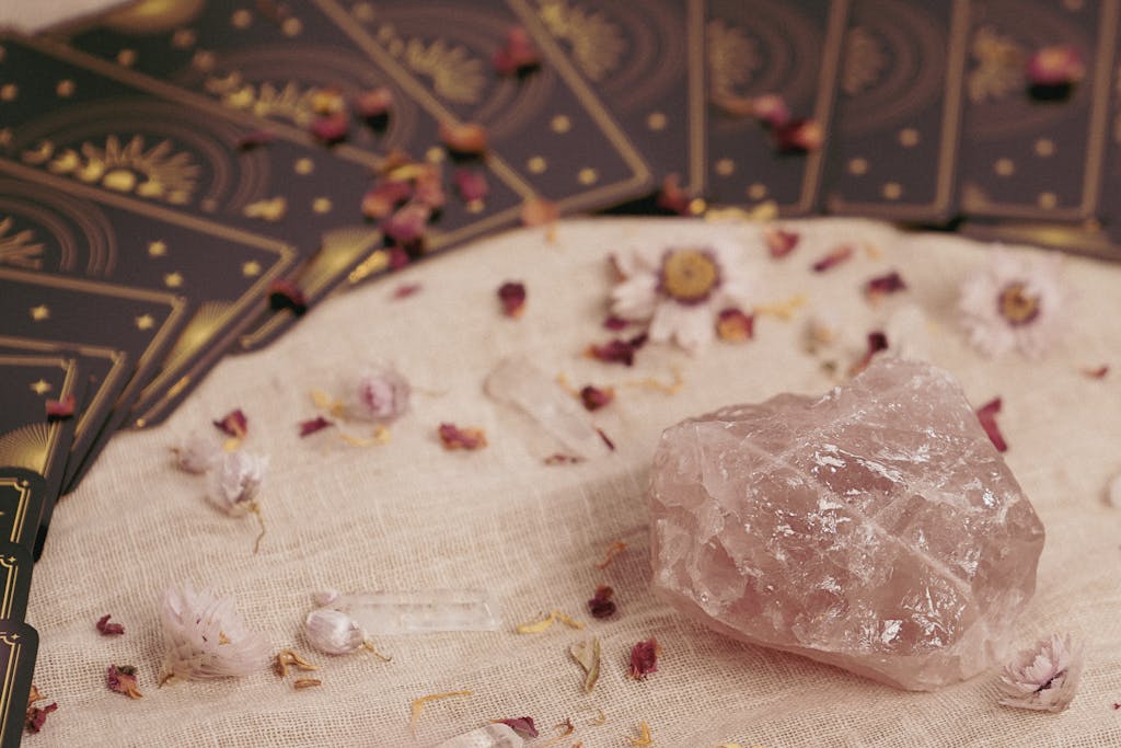 Healing psychic readings can use an arrangement featuring tarot cards, rose quartz, and dried flowers on linen.