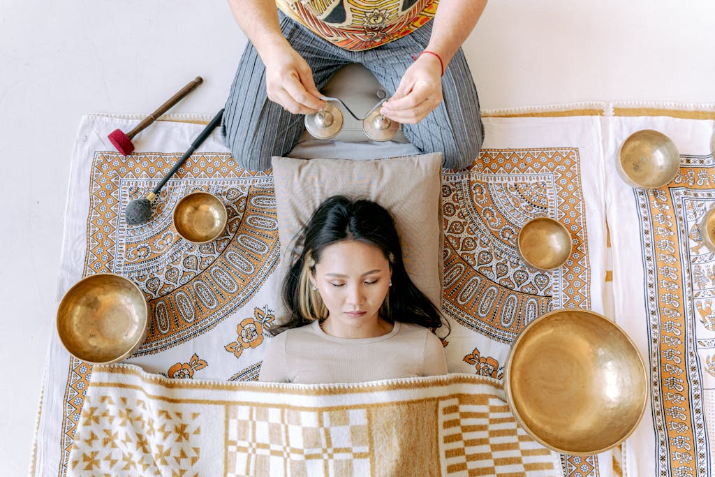 sound wave therapy benefits. A woman enjoying a relaxation session with Tibetan singing bowls for wellness.