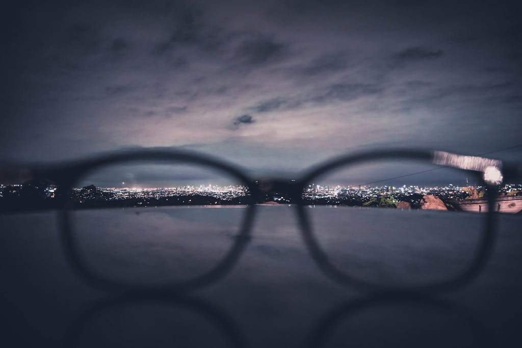 Blurry city lights of Manila seen through eyeglasses at night, creating a unique urban view.