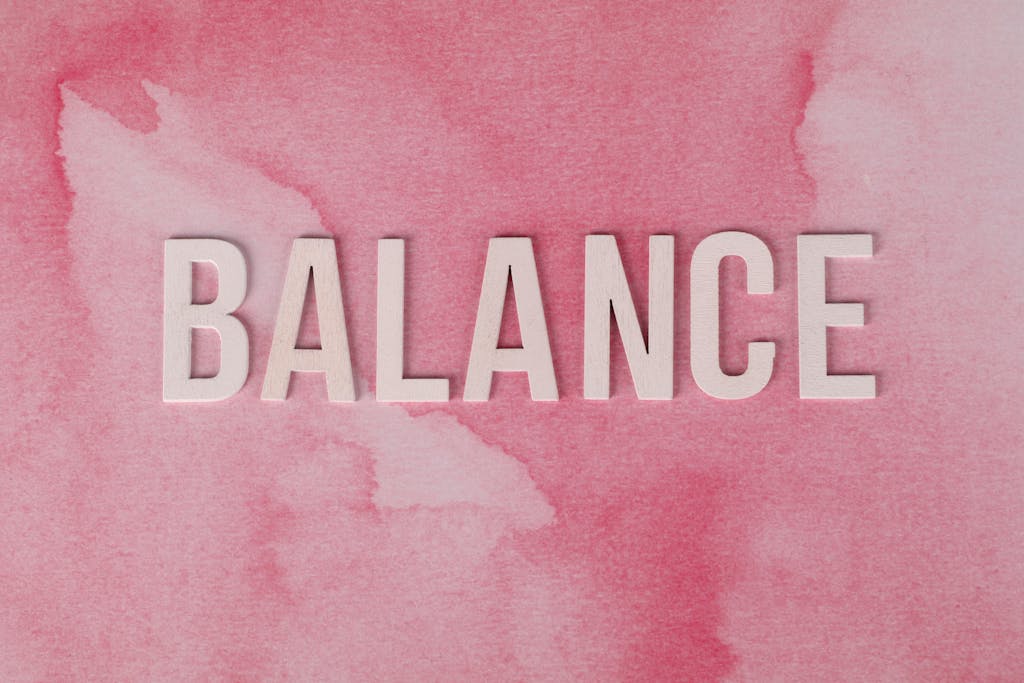 The word 'BALANCE' displayed in bold letters on a pink abstract background.