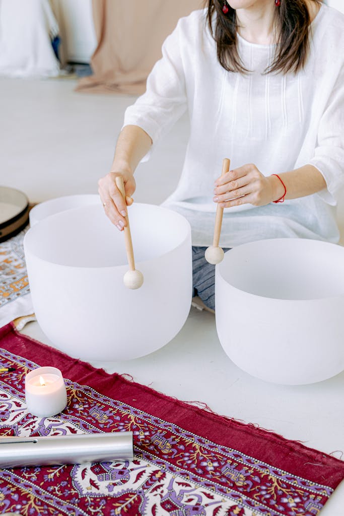 Healing through sound. 
A woman playing crystal singing bowls during a meditation session for relaxation and well-being.