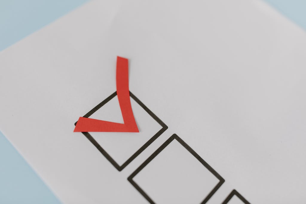 Close-up of a red check mark on a crisp white paper with black boxes, symbolizing completion.