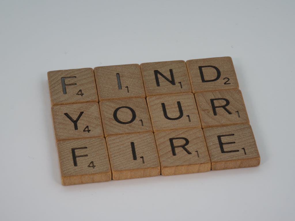 Wooden scrabble tiles arranged to spell 'Find Your Fire' on a white background.